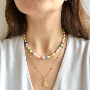 Close-up of double-layered necklace with glacier blue opal beads and sun pendant