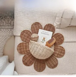Detail of flower-shaped rattan wall basket storing books on a textured white bed