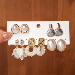 Détail d'un ensemble de boucles d'oreilles baroques avec perles et pétales en tissu