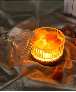 Himalayan salt lamp in ribbed glass jar on wooden base with warm orange glow effect