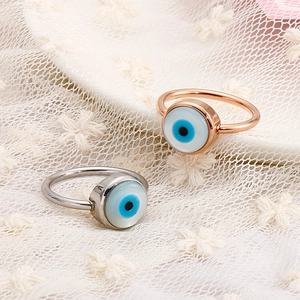 Detailed shot of Lucky Evil Eye pearl rings in rose gold and silver on white lace cloth