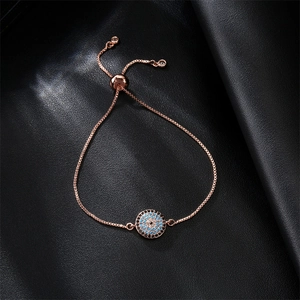 Macro detail of rose gold evil eye bracelet with blue cubic zirconia and sliding clasp