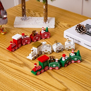Three wooden Christmas train ornaments in red, green and white on a wooden table