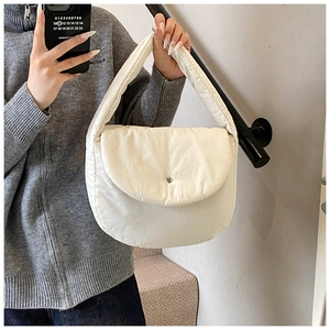 Close-up of padded puffy tote bag with magnetic flap closure and wide shoulder strap