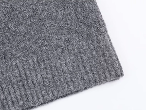 Close-up of grey knit cardigan showing soft plush texture and ribbed cuff details
