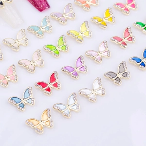 Detailed close-up of colorful butterfly nail charms with enamel finish and small rhinestones