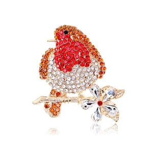 Exquisite bird brooch with red and orange rhinestones on a golden flower branch