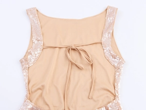 Détail d'une robe dos nu à paillettes champagne avec fermeture à lacets et tissu soyeux