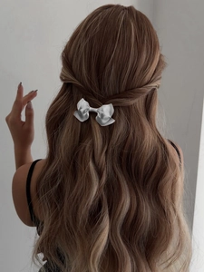 Silver bow metal hair clip shown on half-up wavy brown hair for an elegant look