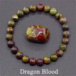 Macro detail of Dragon Blood stone beaded bracelet with red and green textured oval center