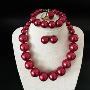 Close-up of elegant red pearl jewelry set including necklace, earrings and ring on mannequin