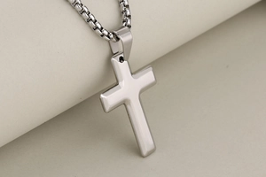 Gros plan détaillé du pendentif croix en acier inoxydable poli avec une chaîne box