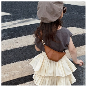 Brown croissant shaped crossbody bag for kids styled with casual street outfit