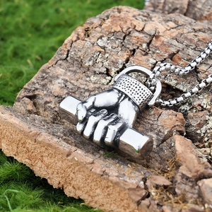 Makroaufnahme eines silbernen Hantelanhängers auf rustikalem Holz mit Edelstahlkette
