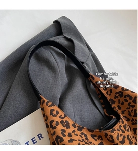 Close-up of leopard print tote bag with black leather handles and texture detail