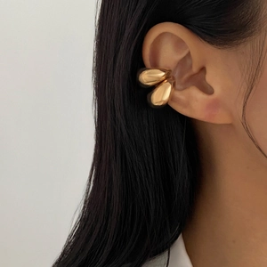 Macro shot of gold double teardrop ear cuff with minimalist multilayer hollow design