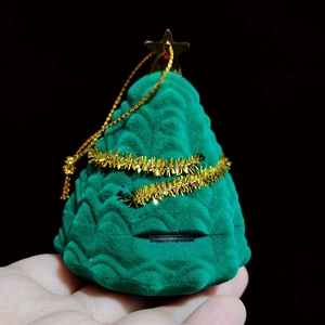 Detail of green velvet Christmas tree jewelry box with gold star and glitter garland