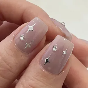Detailaufnahme von rosa Nagelkunst mit silbernen Sternen und glitzernden Strasssteinen
