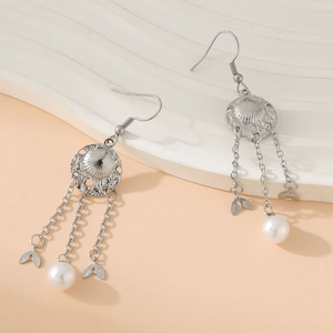 Silver alloy fishtail chain tassel earrings with pearls on a textured background