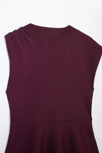Detail of burgundy sleeveless knitted mini dress showing asymmetric cut and fabric texture