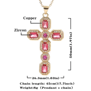 Detailopname van gouden koperen kruishanger met rode zirkonia en bijpassende ketting
