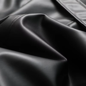 Macro close-up of premium black faux leather texture with fine lychee grain and soft sheen