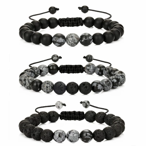 Detail of three-piece beaded bracelet set featuring black lava stone and snowflake obsidian