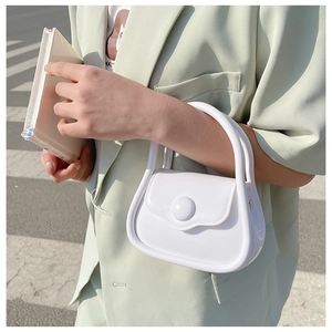 Detail of white mini macaron jelly bag with round magnetic clasp and top handle grip