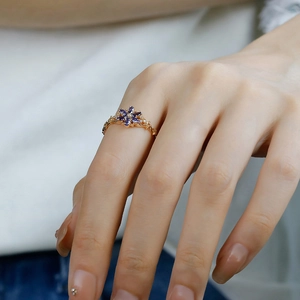 Detail of vintage 14K gold plated flower ring with purple gems and filigree band