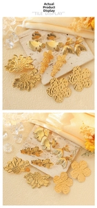 Detailed macro shot of gold ginkgo leaf earrings with brushed metal texture and floral design