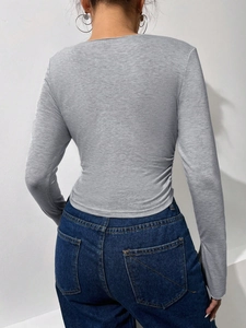 Eng anliegendes graues Langarmshirt für Damen mit seitlicher Raffung und kurzem Saum