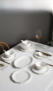 Detailed view of white ceramic dinnerware set with exquisite western embossed lace edges
