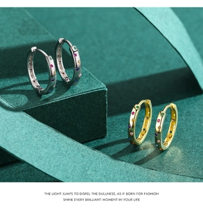 Close-up of gold and silver S925 sterling silver huggie earrings with rainbow zircon stones