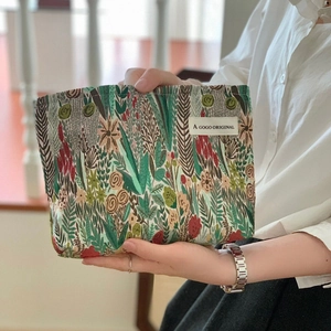 Detail of floral canvas makeup bag with woven fabric texture and original side label