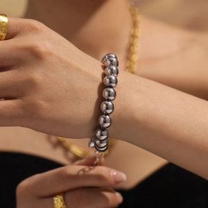 Polished stainless steel hollow bead bracelet with adjustable lobster clasp on wrist