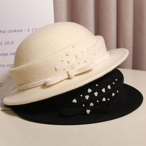 Detail of vintage wool cloche hats with bow, pearls and floral accents in French style