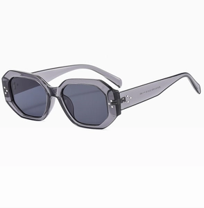 Detail view of futuristic polygonal sunglasses featuring silver rivets and grey frame
