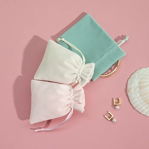 Detailed plush velvet drawstring jewelry pouches in pink, beige, and mint green