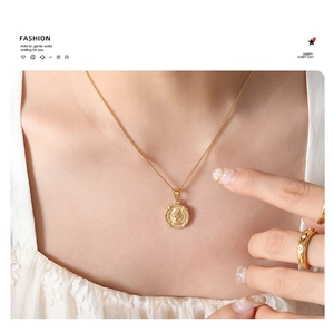 Close-up of a French vintage gold relief queen coin pendant necklace on a model