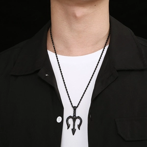 Détail d'un homme portant un pendentif trident noir sur un t-shirt blanc et veste sombre