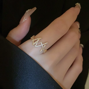 Close-up of gold-plated double-layer ring featuring zircons and pearl tassel on finger