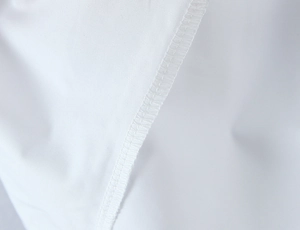 Close-up of white retro puff sleeve shirt showing professional lockstitch sewing and fabric