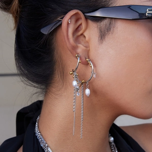 Detailed close-up of 18K gold and silver two-tone pearl tassel earrings with fine chain