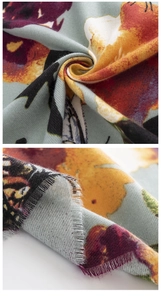 Detail of blue-grey scarf featuring orange butterfly print and fringe tassels texture