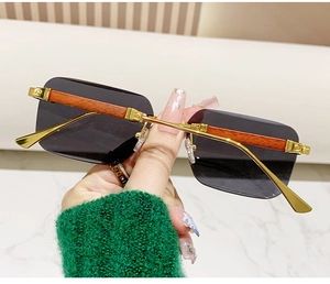 Detail of wood grain temples and gold metal accents on rimless square sunglasses