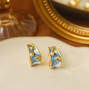 Vintage ocean-themed C-shaped gold earrings with blue enamel, starfish, and shell details