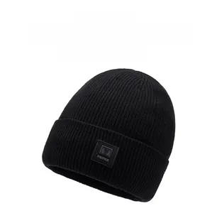 Close-up of black ribbed knit beanie with thick cuff and square rubber logo patch