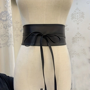 Women's wide black corset belt with elegant bow tie design on a professional mannequin