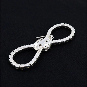 Detailed back view of a silver bow brooch with a secure horizontal safety pin clasp