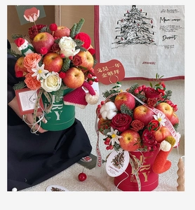 Detail of Christmas flower bucket with red roses, apples and gold foil lettering decoration